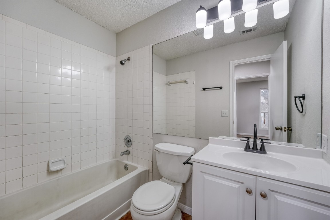 1002 Rambling Trail Cedar Park, TX 78613 - Photo 19 of 23 a bathroom with a sink a toilet a mirror a vanity and bathtub