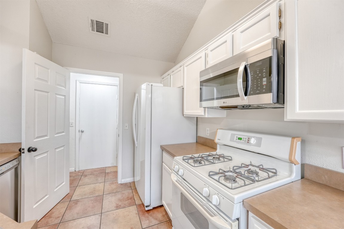 1002 Rambling Trail Cedar Park, TX 78613 - Photo 10 of 23 a kitchen with stainless steel appliances granite countertop a stove refrigerator and microwave