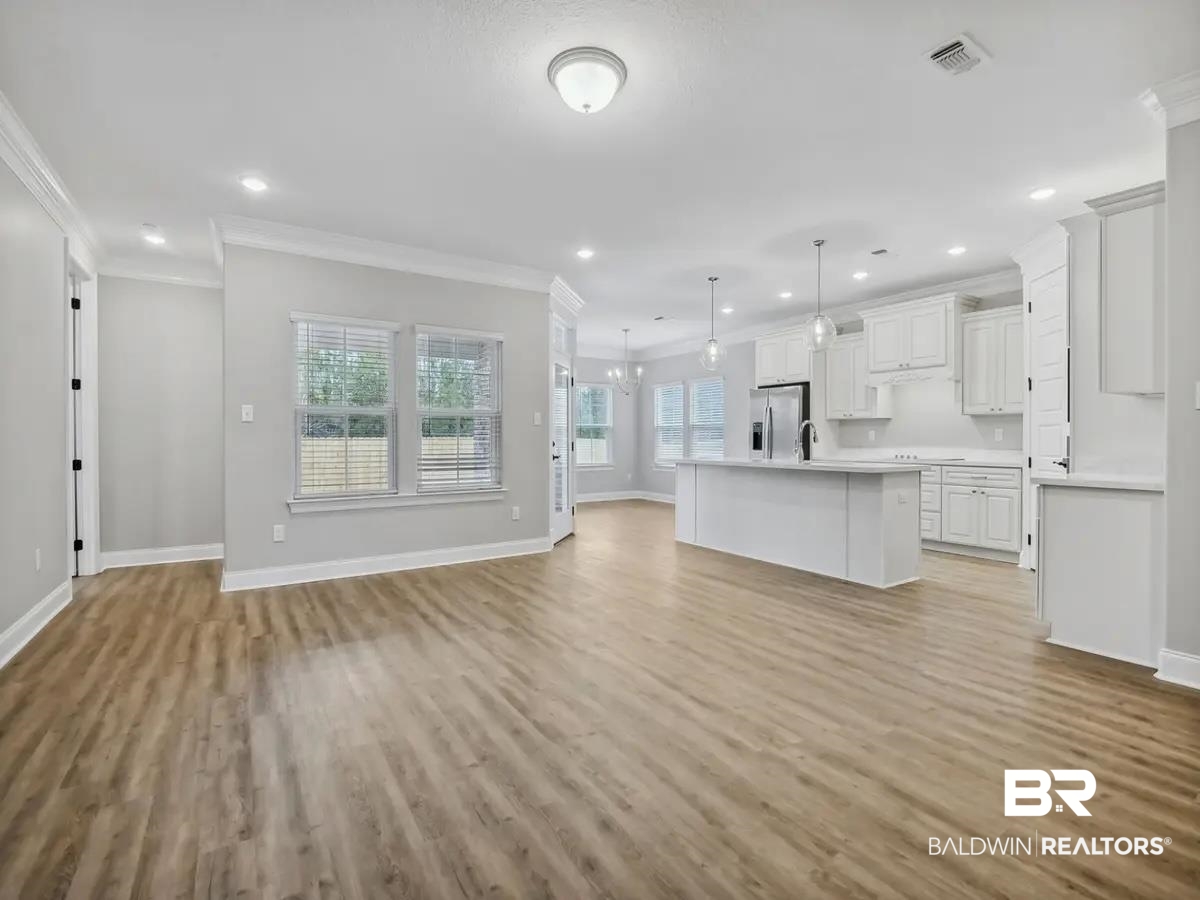 10174 Grady Lane Mobile, AL 36695 - Photo 3 of 14 Unfurnished living room featuring ornamental molding, suspended lighting, and light wood-style flooring