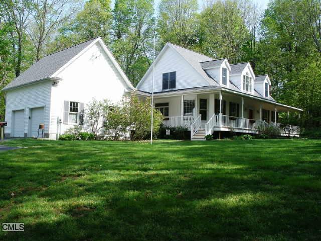 a view of a house with a big yard plants and large trees