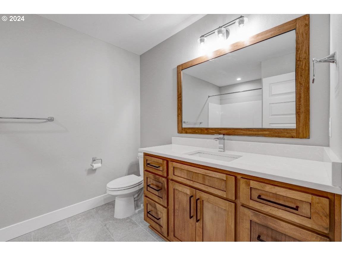 4120 South 17th Way Ridgefield, WA 98642 - Photo 19 of 20 a bathroom with a granite countertop toilet sink and mirror