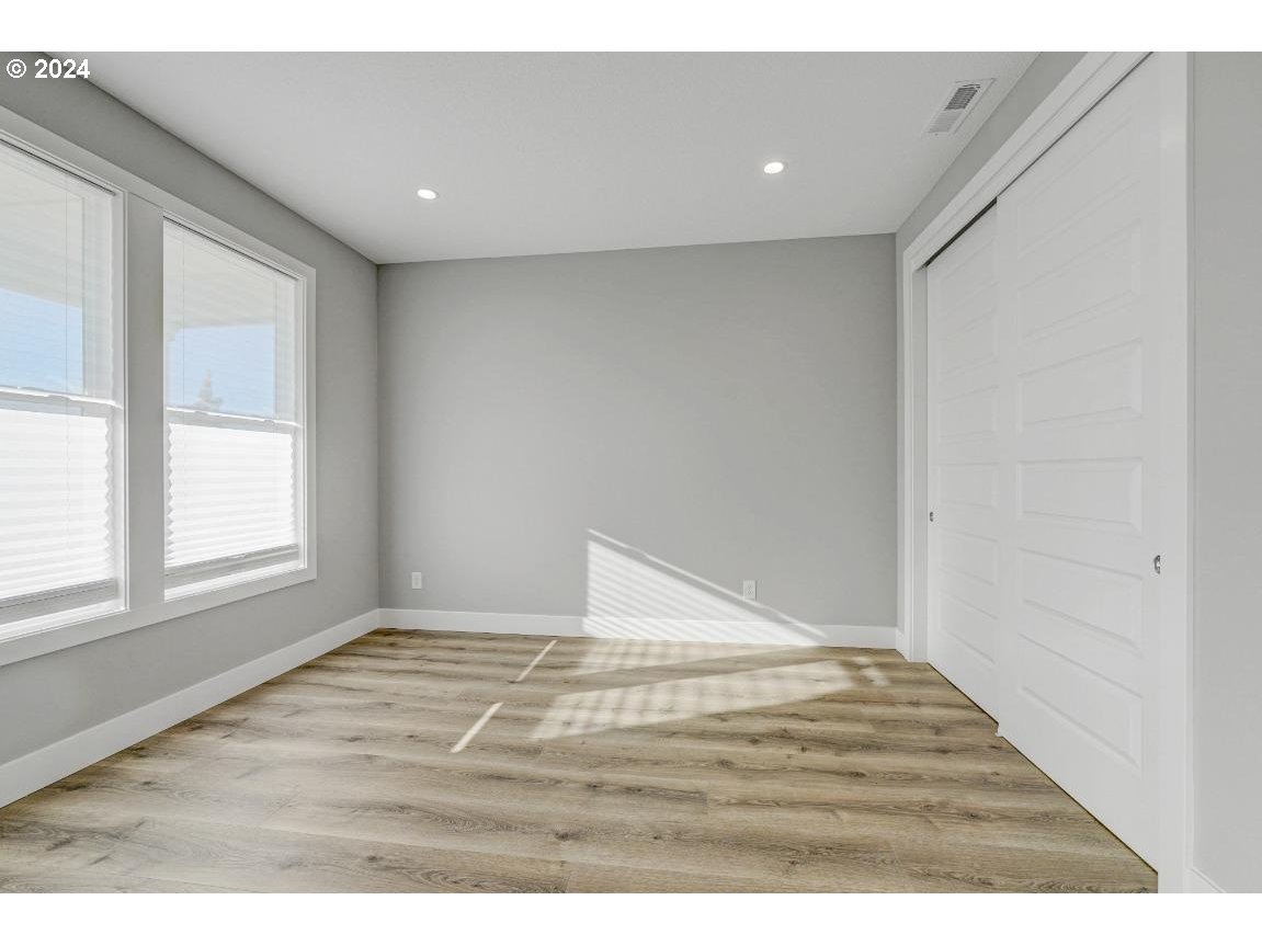 4120 South 17th Way Ridgefield, WA 98642 - Photo 3 of 20 a view of an empty room with wooden floor and a window