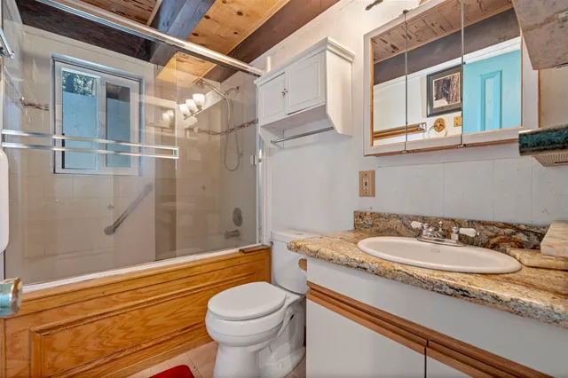 a bathroom with a sink a toilet and shower