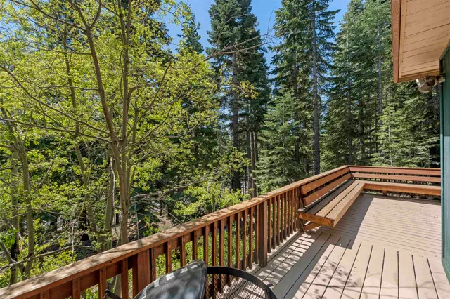 a view of a patio with wooden floor table and chairs