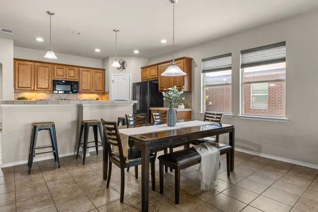 a kitchen with kitchen island a dining table and chairs