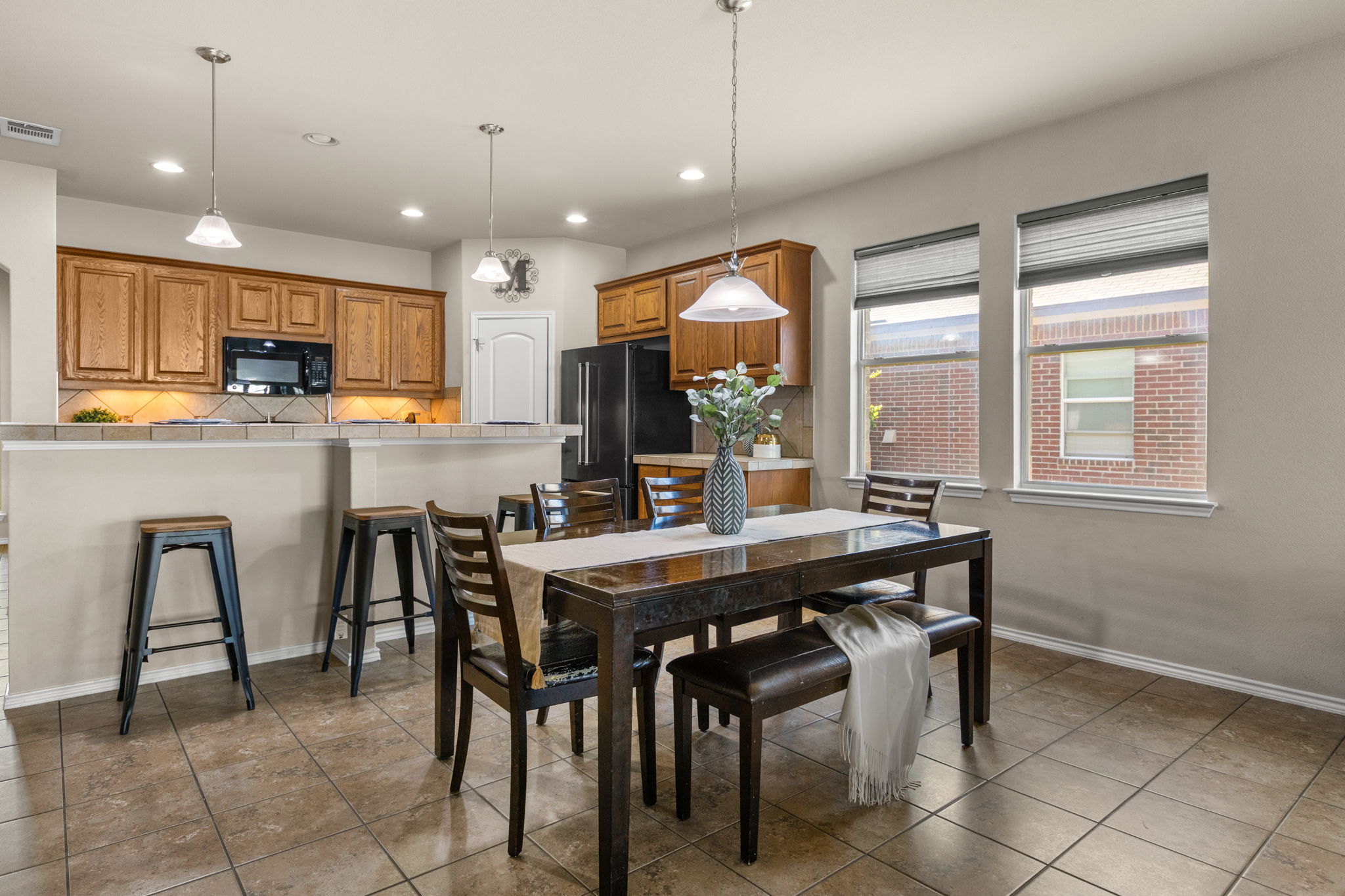 221 Blossom Valley Streme Buda, TX 78610 - Photo 12 of 40 a kitchen with kitchen island a dining table and chairs