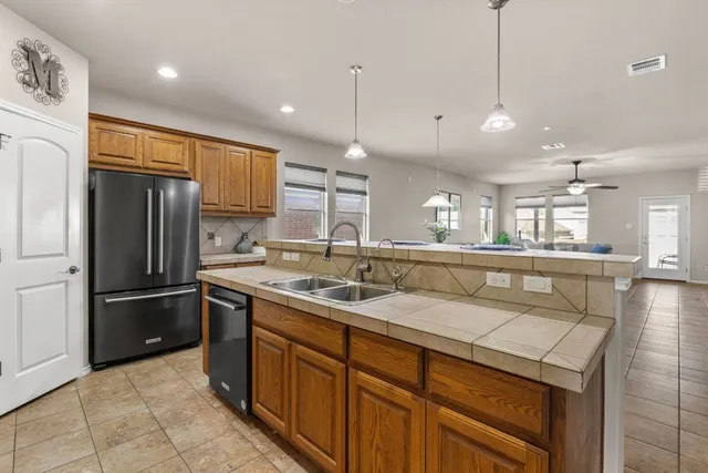 a kitchen with kitchen island a sink stainless steel appliances and cabinets