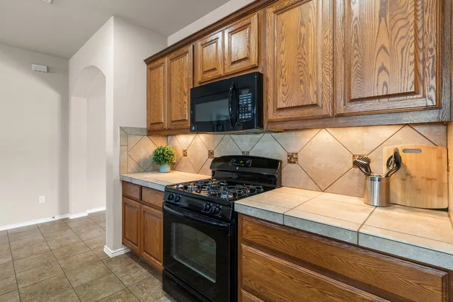 a kitchen with wooden cabinets and a stove top oven