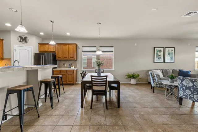 a dining room with furniture a chandelier and kitchen view