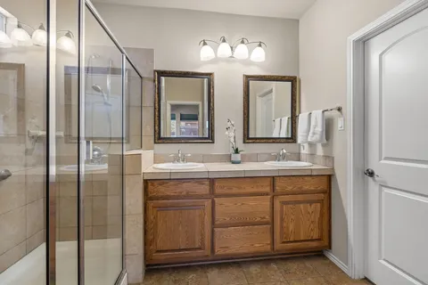 a bathroom with a shower sink and mirror