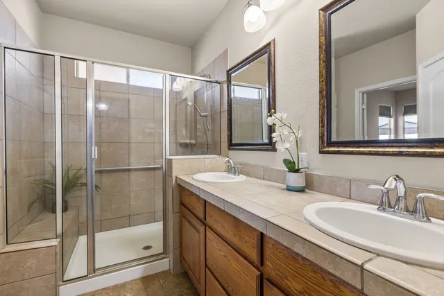 a bathroom with a shower sink and mirror