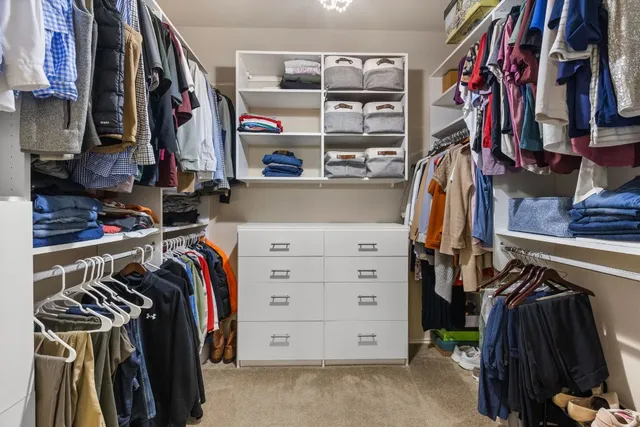 a view of walk in closet with clothes and shoes