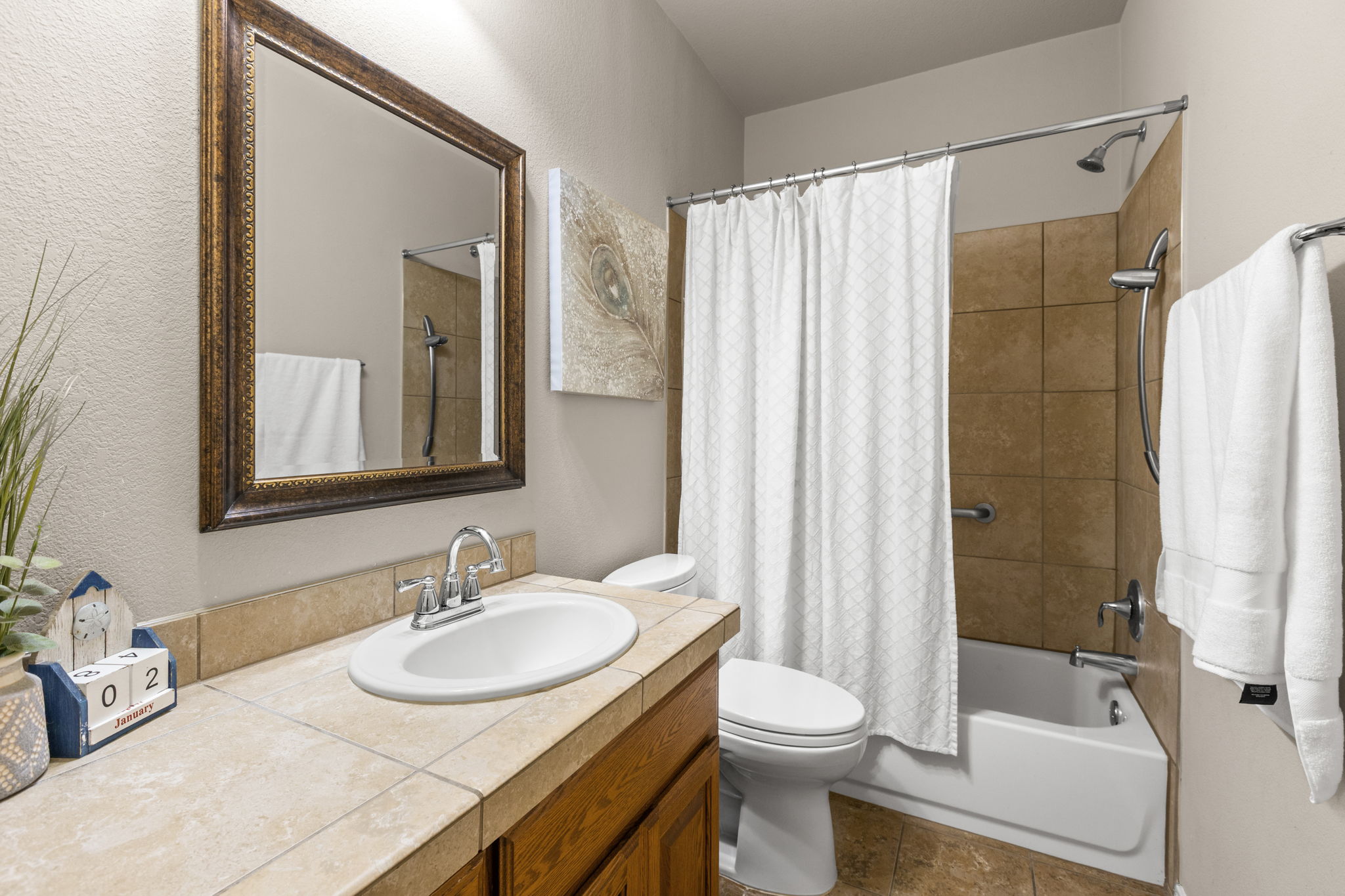 221 Blossom Valley Streme Buda, TX 78610 - Photo 27 of 40 a bathroom with a granite countertop sink toilet a mirror a bathtub and shower