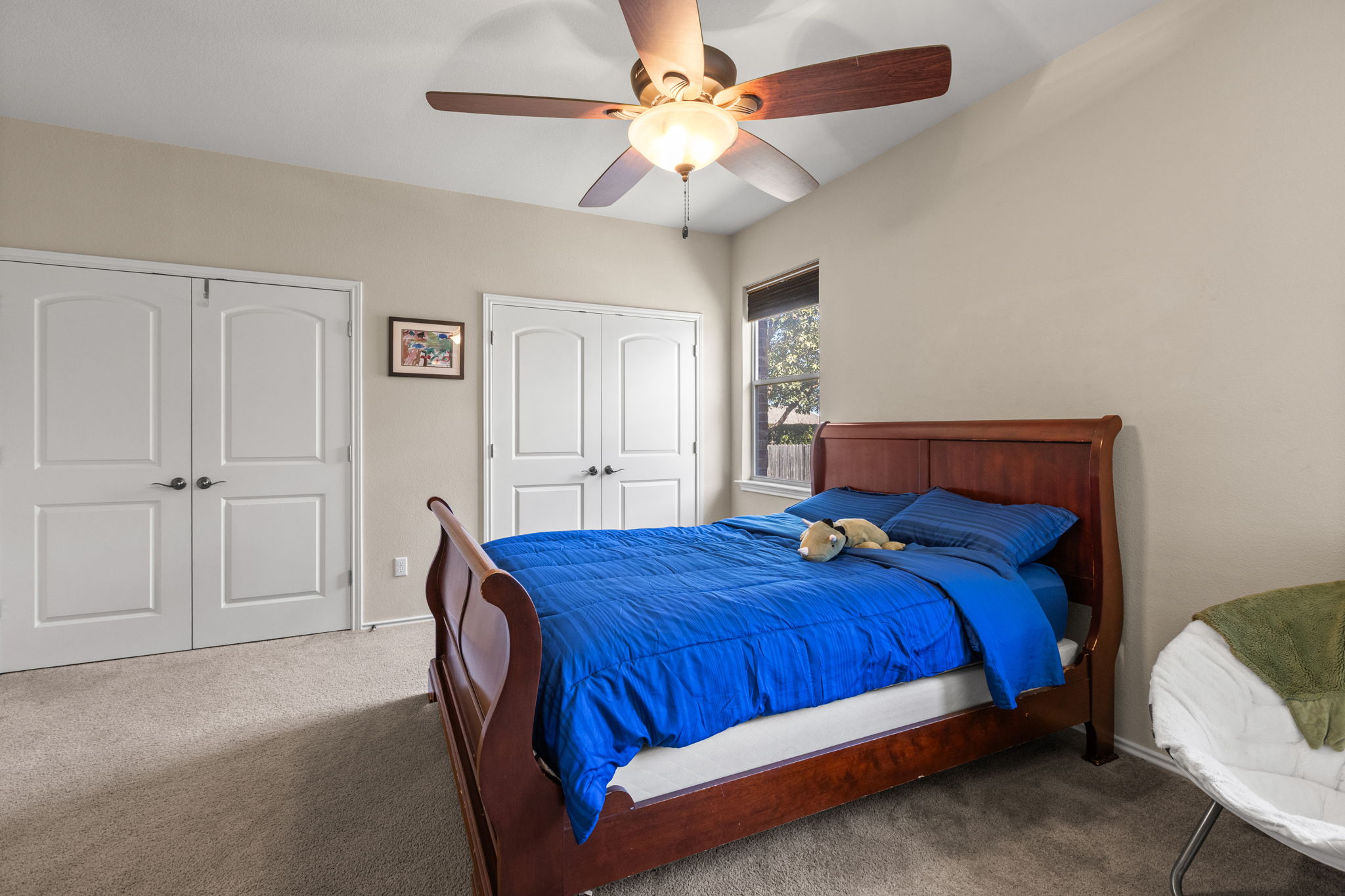 221 Blossom Valley Streme Buda, TX 78610 - Photo 32 of 40 a bedroom with a bed and a chandelier