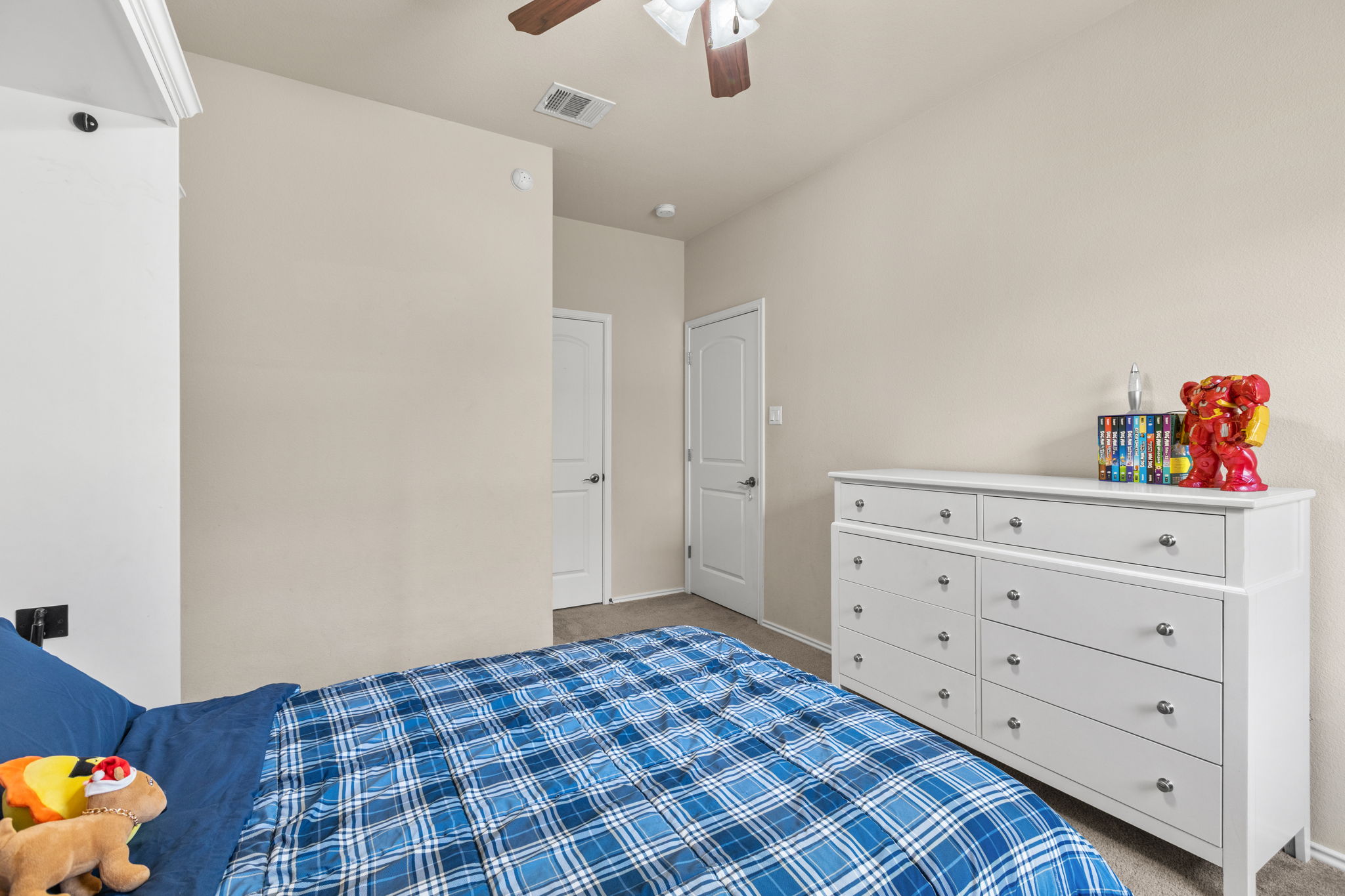 221 Blossom Valley Streme Buda, TX 78610 - Photo 34 of 40 a bedroom with a dresser and a chandelier fan