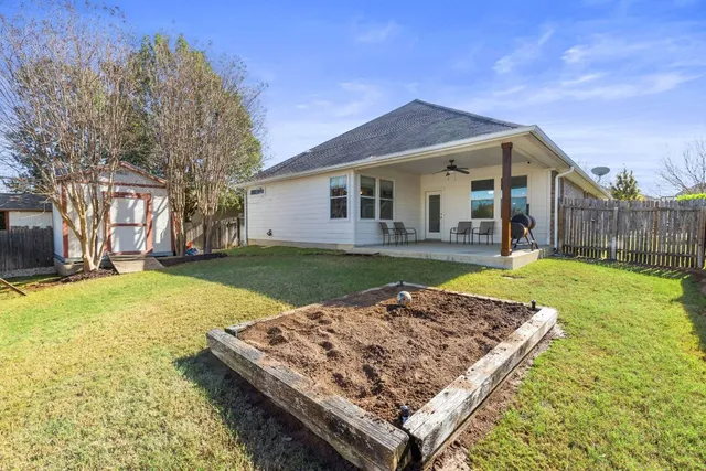 a view of a house with a yard patio and fire pit