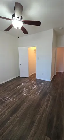 a view of a room with a ceiling fan window and a ceiling fan