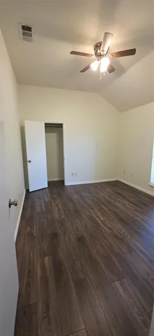 a view of a room with wooden floor and fan