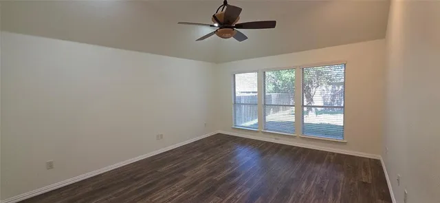 a view of wooden floor and a chandelier fan in a room