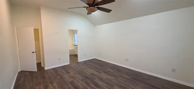 an empty room with wooden floor and ceiling fan