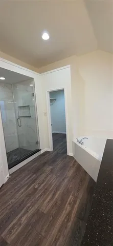 an empty room with wooden floor and door