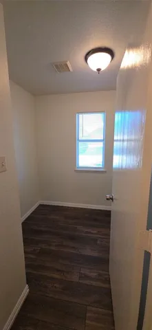 a view of room with wooden floor and windows