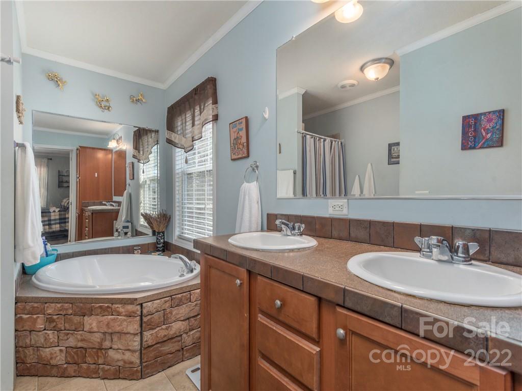 6232 Panther Creek Road Clyde, NC 28721 - Photo 12 of 25 a bathroom with a sink double vanity granite tub shower and a mirror