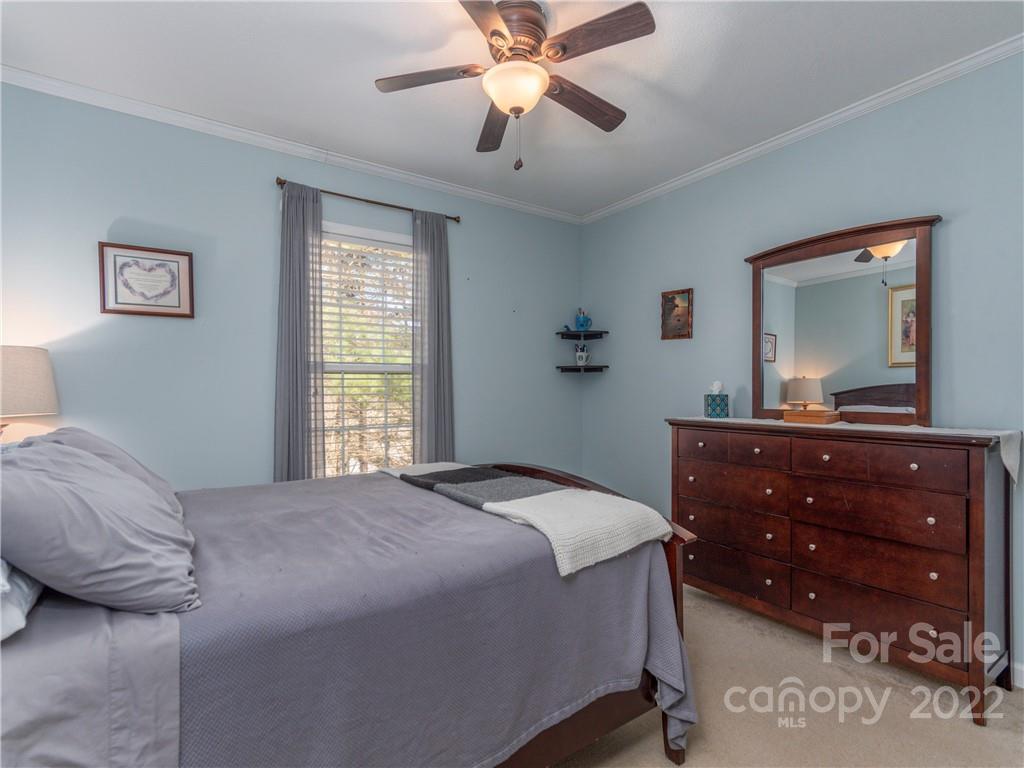 6232 Panther Creek Road Clyde, NC 28721 - Photo 13 of 25 a bedroom with a bed and a mirror on dresser