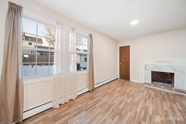 wooden floor fireplace and windows in an empty room