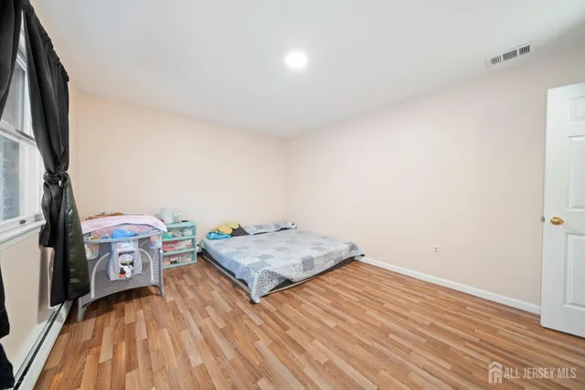a bedroom with a bed and a flat tv screen on dresser