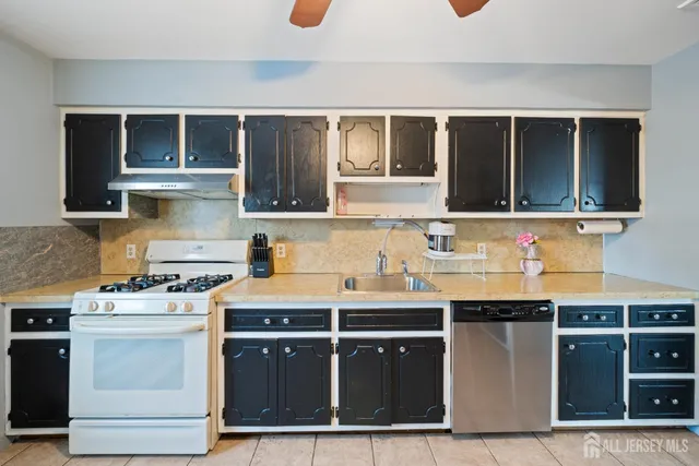 a kitchen with stainless steel appliances granite countertop a stove a sink dishwasher and a microwave oven with wooden cabinets