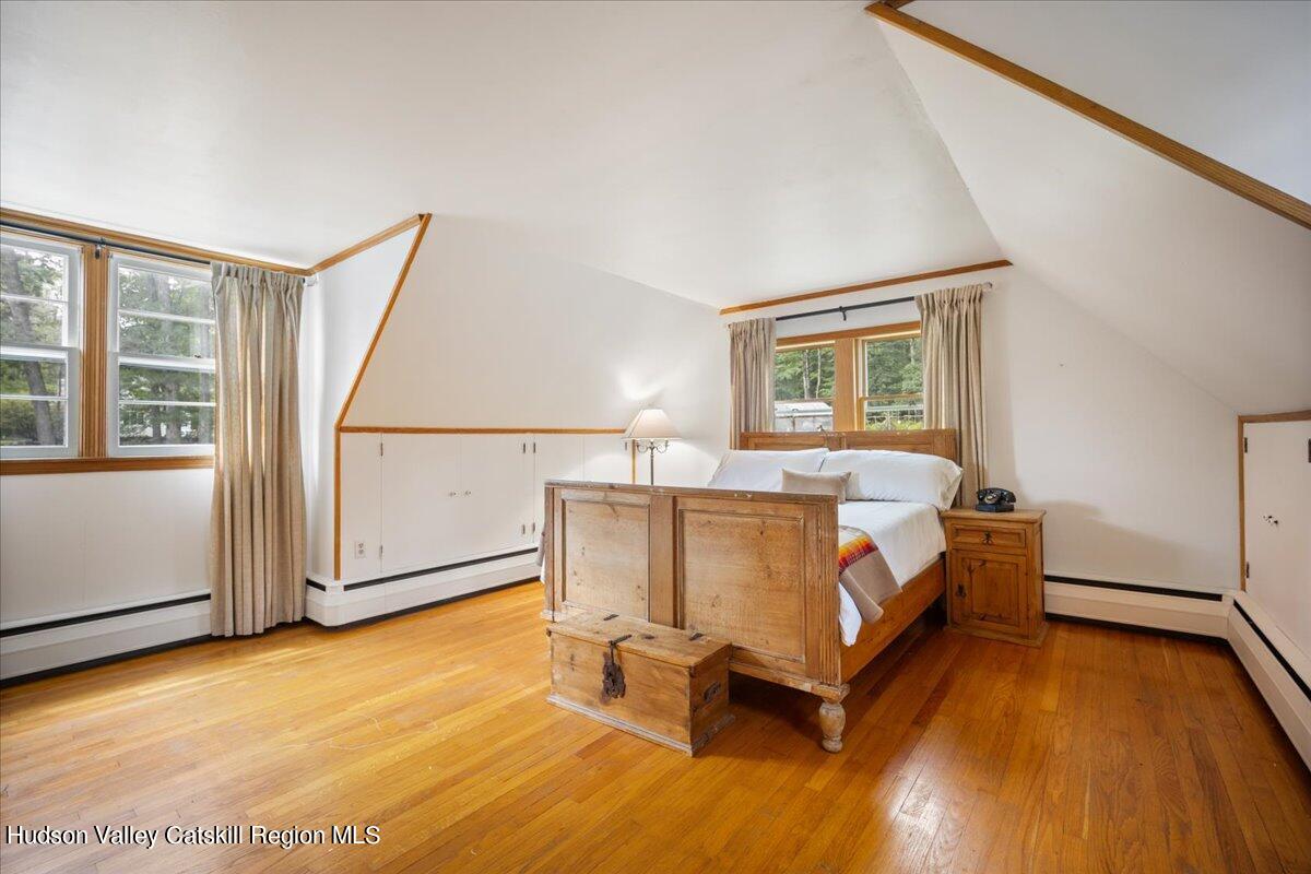 32 West Hurley Road, Unit ROUTE 375 Woodstock, NY 12498 - Photo 14 of 36 a spacious bedroom with a bed and wooden floor