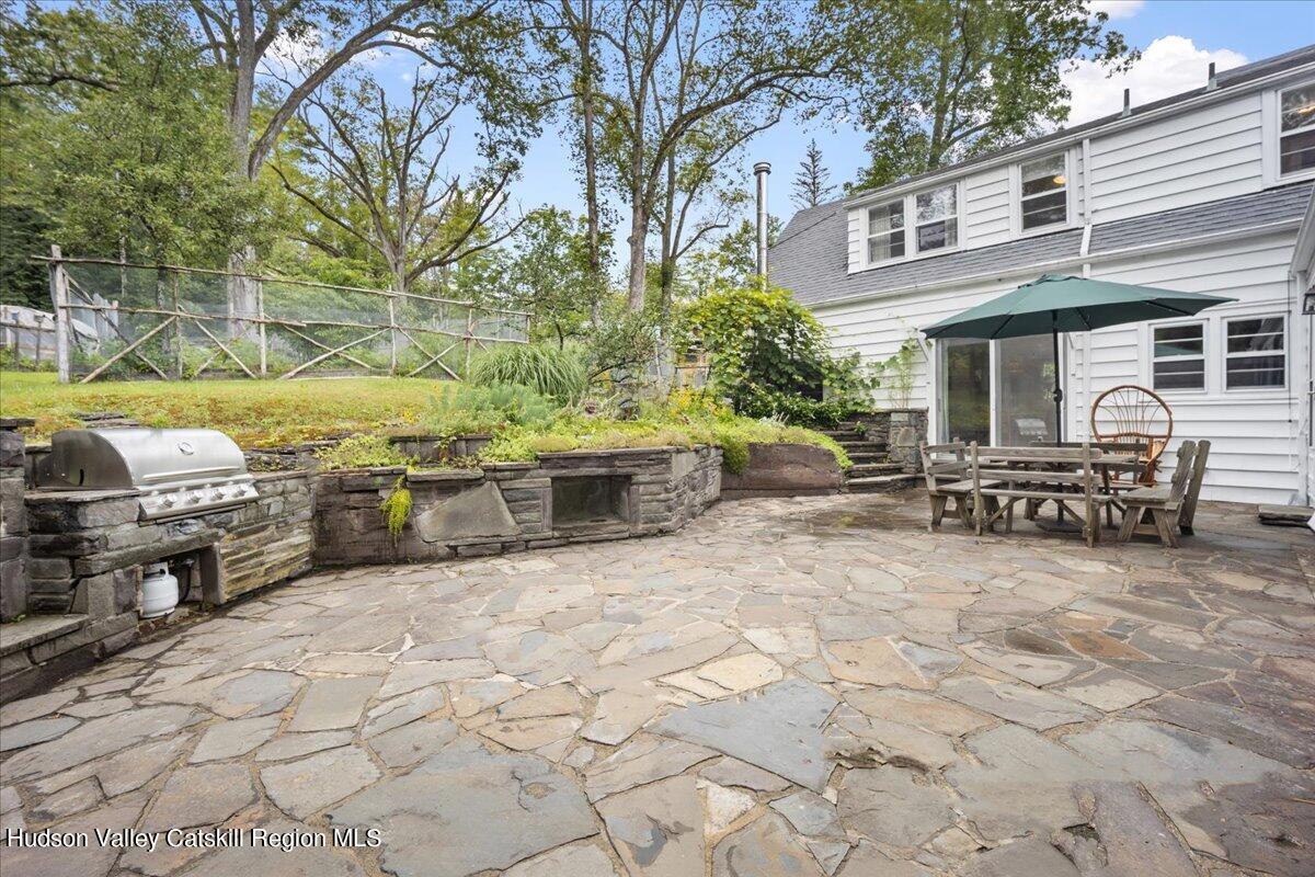 32 West Hurley Road, Unit ROUTE 375 Woodstock, NY 12498 - Photo 20 of 36 a view of a chairs and table in the back yard of the house