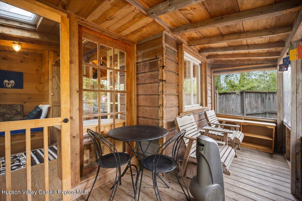 32 West Hurley Road, Unit ROUTE 375 Woodstock, NY 12498 - Photo 28 of 36 a view of a patio with table and chairs with wooden floor and fence