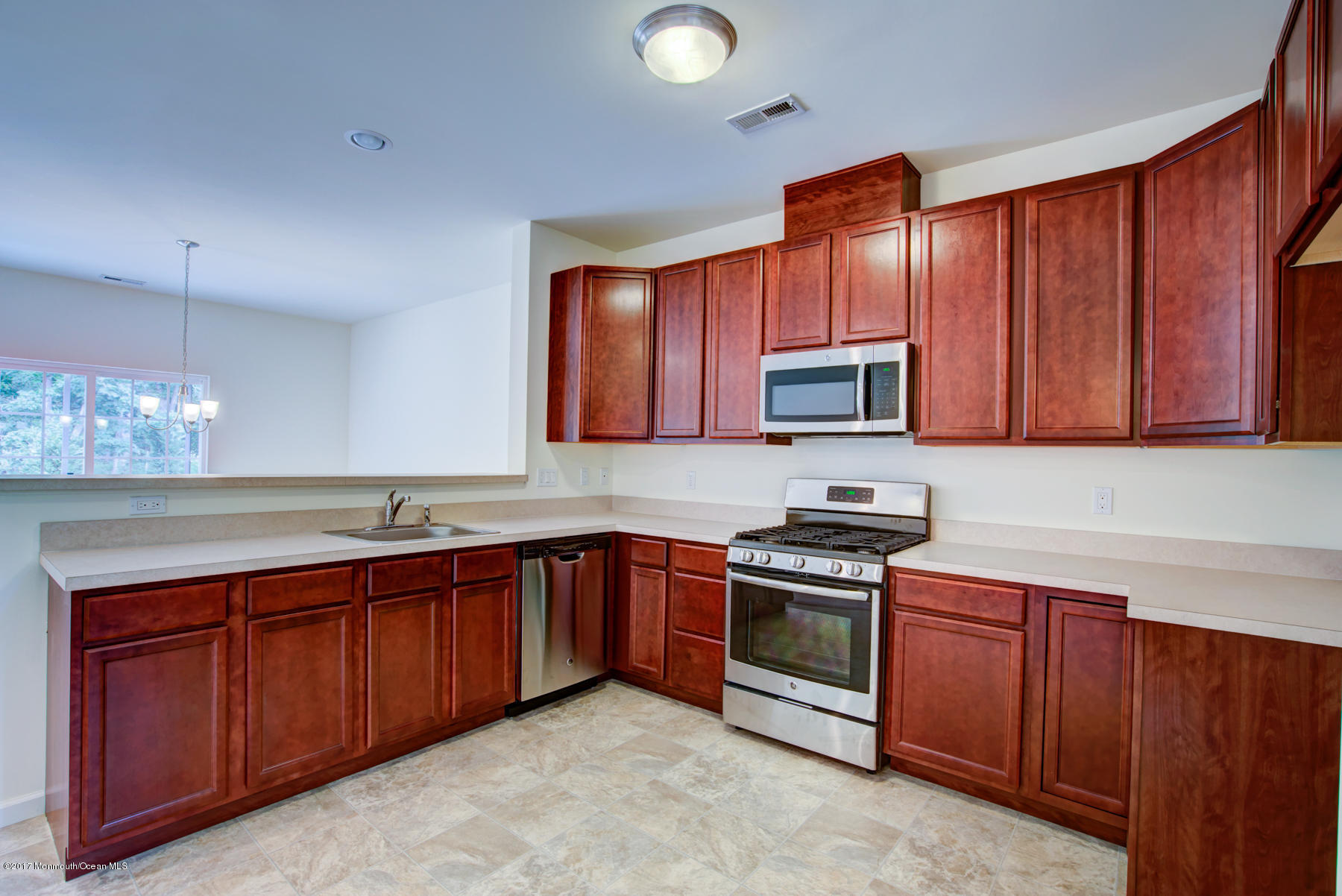 53 Rockingham Way Manchester Township, NJ 08759 - Photo 5 of 17 a kitchen with stainless steel appliances granite countertop wooden cabinets a stove top oven a sink and dishwasher
