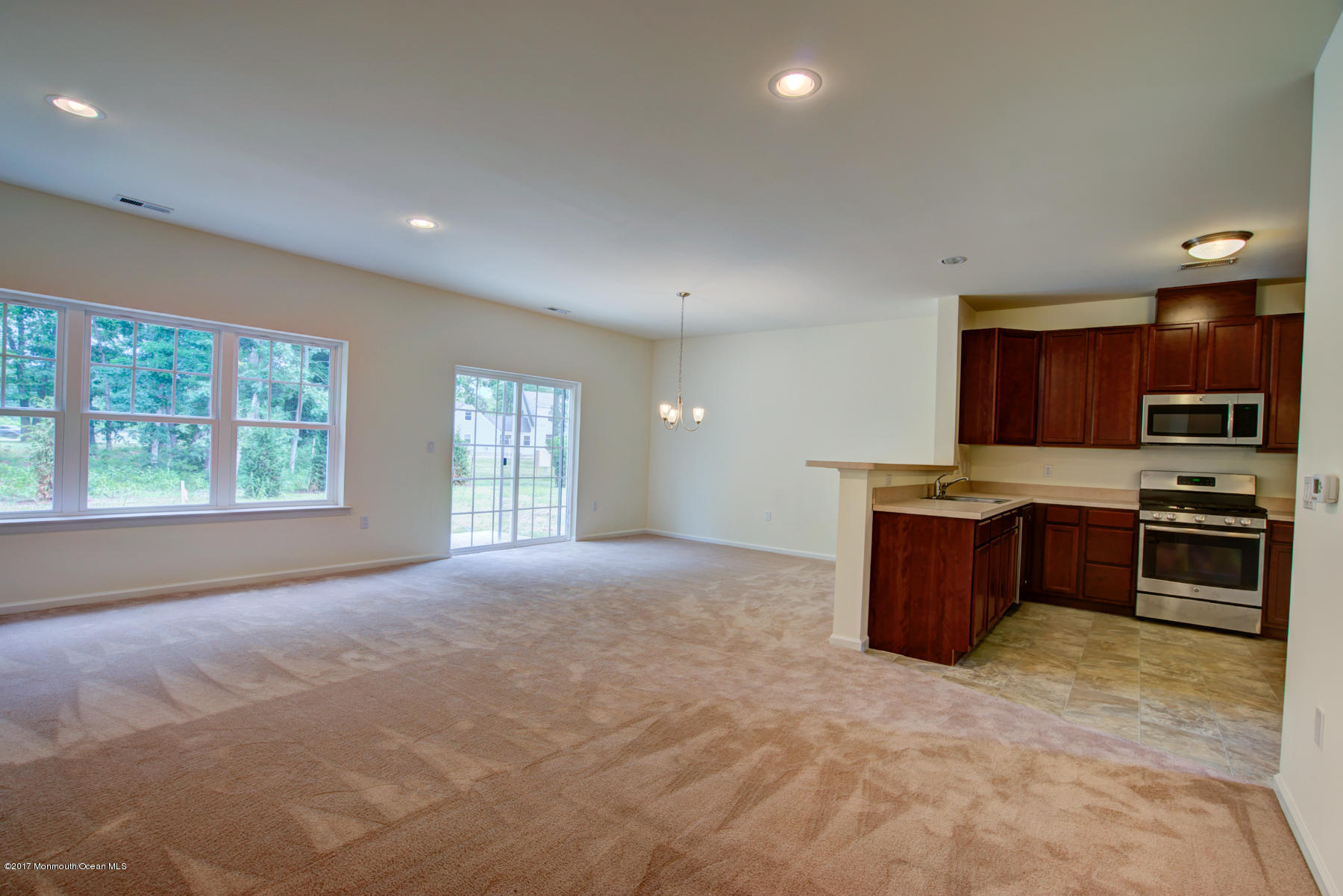 53 Rockingham Way Manchester Township, NJ 08759 - Photo 7 of 17 a large kitchen with stainless steel appliances granite countertop a stove a sink dishwasher a microwave oven with cabinets and large window