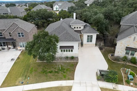 an aerial view of a house with a yard and large tree