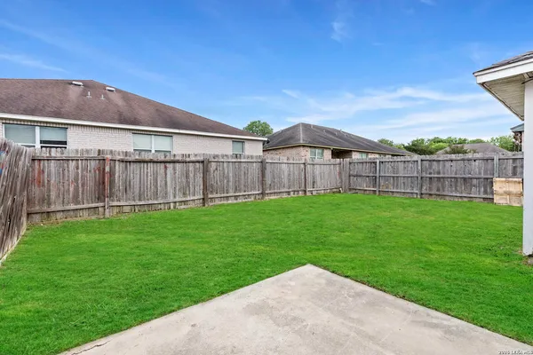 a view of a yard with a large trees and a wooden fence
