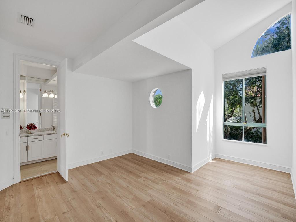 8850 Southwest 67th Court Pinecrest, FL 33156 - Photo 21 of 49 wooden floor in an empty room with a window