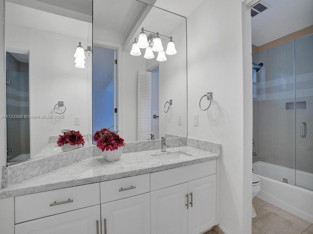 8850 Southwest 67th Court Pinecrest, FL 33156 - Photo 23 of 49 a bathroom with a sink double vanity granite tub shower and a mirror