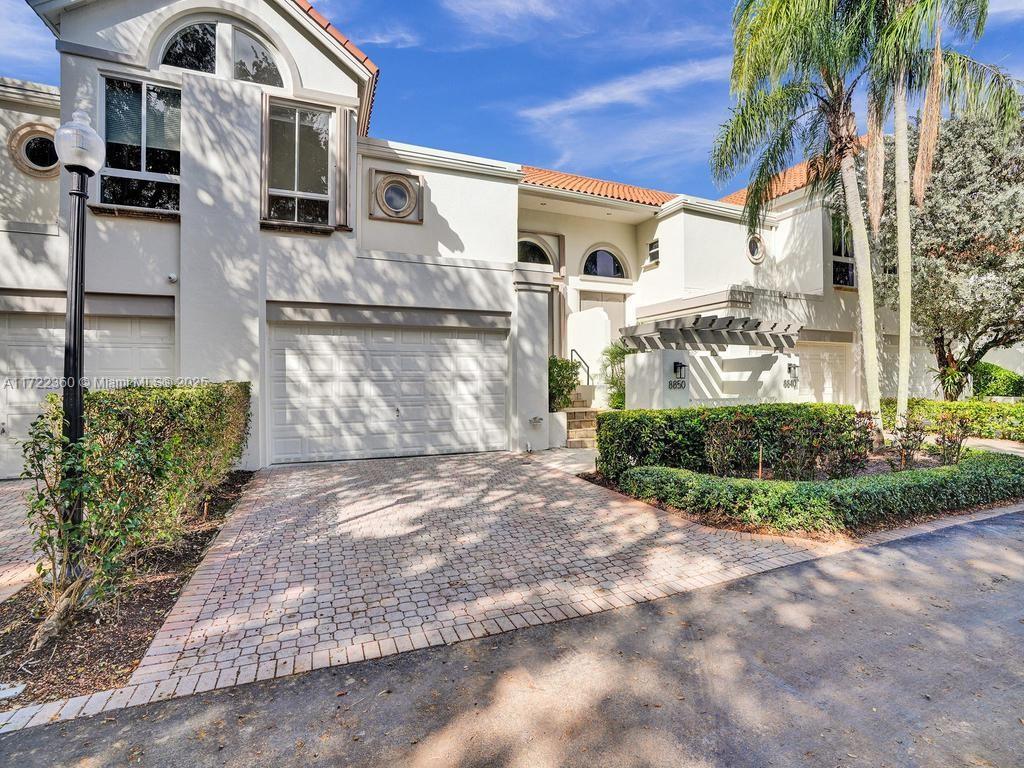 8850 Southwest 67th Court Pinecrest, FL 33156 - Photo 3 of 49 a view of a white house with large windows and a yard