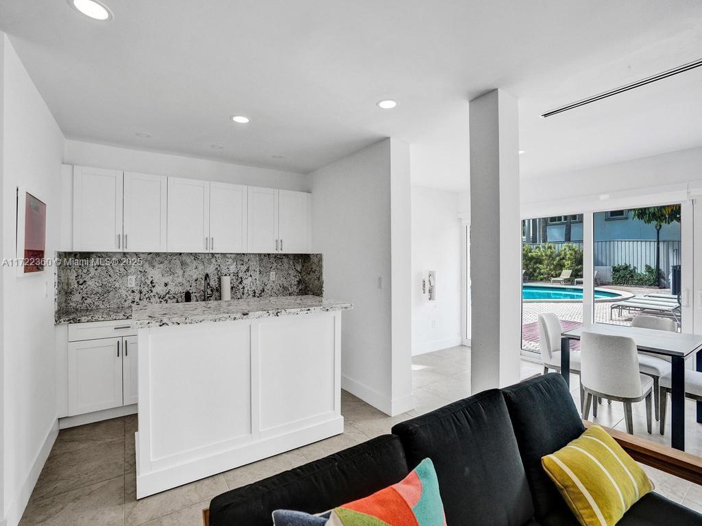 8850 Southwest 67th Court Pinecrest, FL 33156 - Photo 45 of 49 a kitchen with stainless steel appliances granite countertop a stove a refrigerator a sink and white cabinets with wooden floor