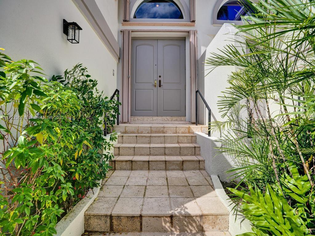 8850 Southwest 67th Court Pinecrest, FL 33156 - Photo 5 of 49 a front view of a house with a yard