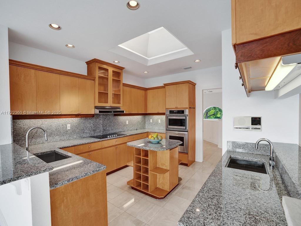 8850 Southwest 67th Court Pinecrest, FL 33156 - Photo 7 of 49 a kitchen that has a sink and a stove in it