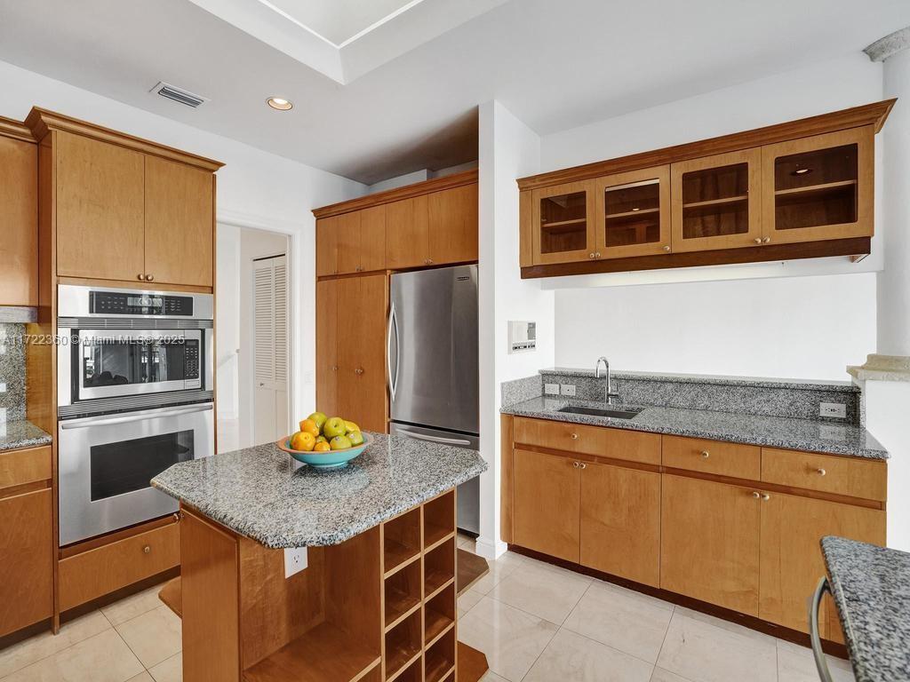 8850 Southwest 67th Court Pinecrest, FL 33156 - Photo 9 of 49 a kitchen with stainless steel appliances granite countertop a stove refrigerator and a microwave