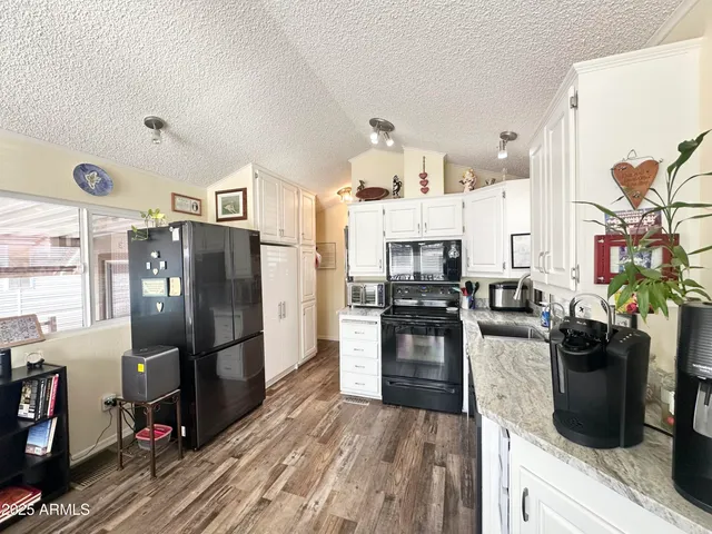 a metallic refrigerator freezer and a stove sitting inside of a kitchen
