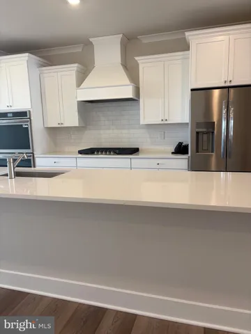 a kitchen with stainless steel appliances a sink a stove a refrigerator and cabinets