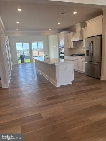 a kitchen with stainless steel appliances granite countertop a refrigerator and a stove top oven