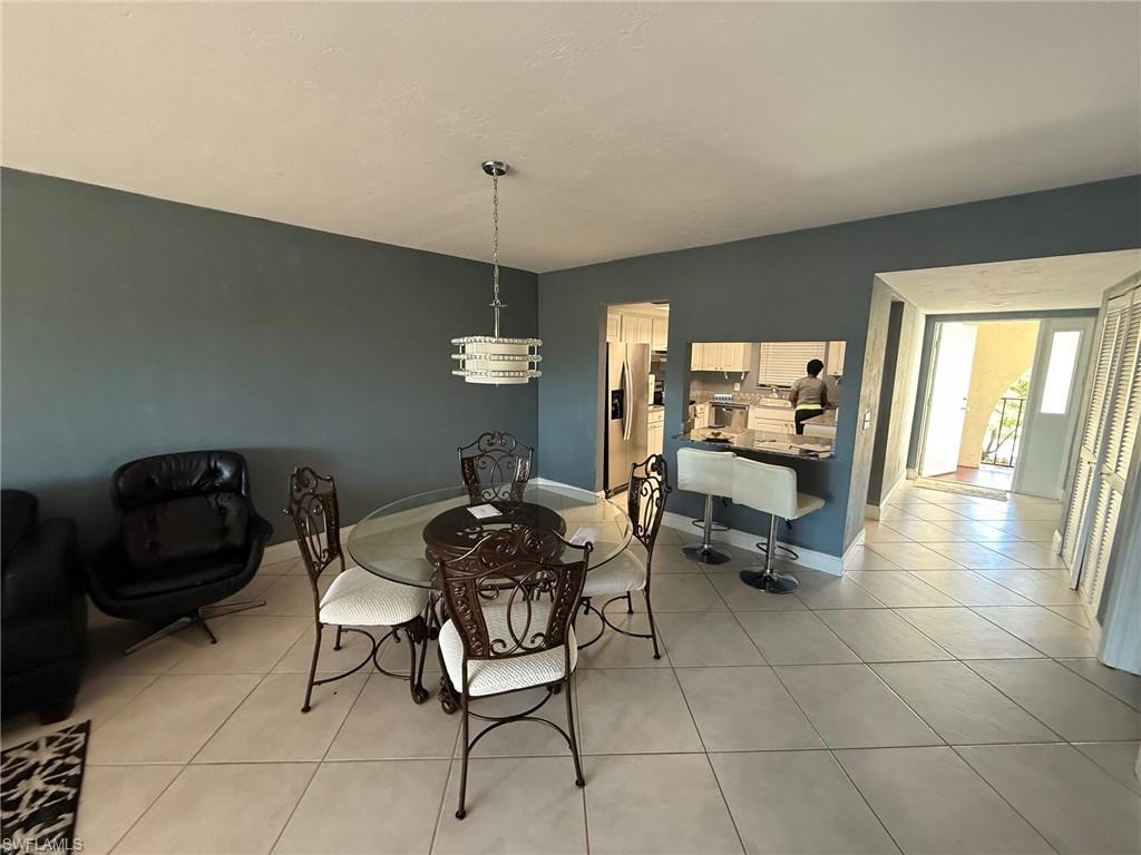 700 Valley Stream Drive, Unit 303 Naples, FL 34113 - Photo 2 of 9 a living room with furniture and a chandelier