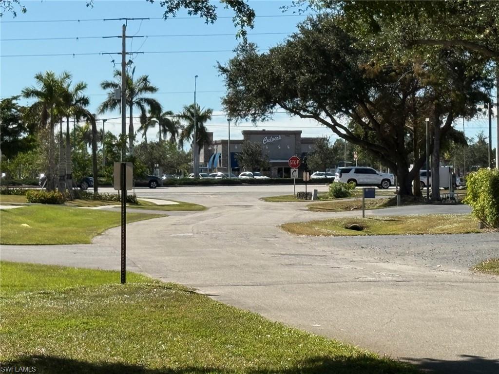 700 Valley Stream Drive, Unit 303 Naples, FL 34113 - Photo 8 of 9 a swimming pool with trees in the background